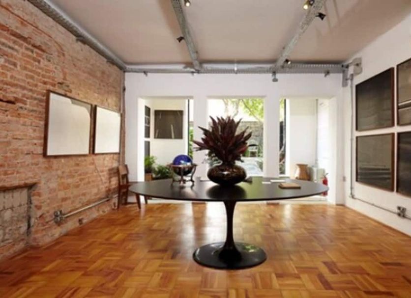 Guest Urban Hotel Design Pinheiros in Sao Paulo: stylish lobby with brick wall, wood floor, and central table