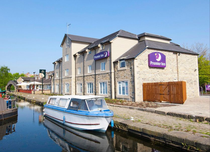 Premier Inn Huddersfield Central by canal with moored boat in Huddersfield