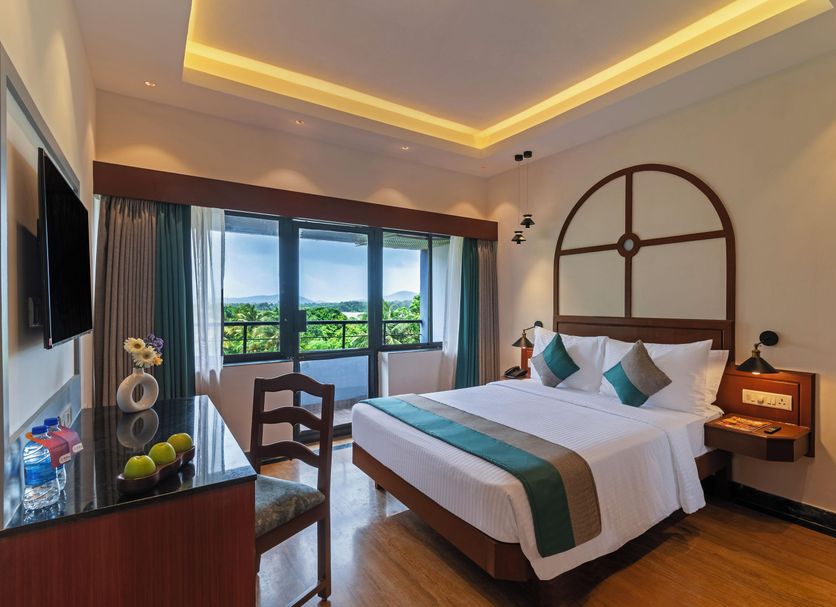 Sterling Karwar room with king bed, balcony and lush green view in Karwar