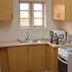 Junbic Apartment and Suites Abuja kitchen with cabinets, sink, window and stove