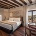 Áurea Toledo by Eurostars Hotel company room with stone wall, wood beams and hillside view in Toledo