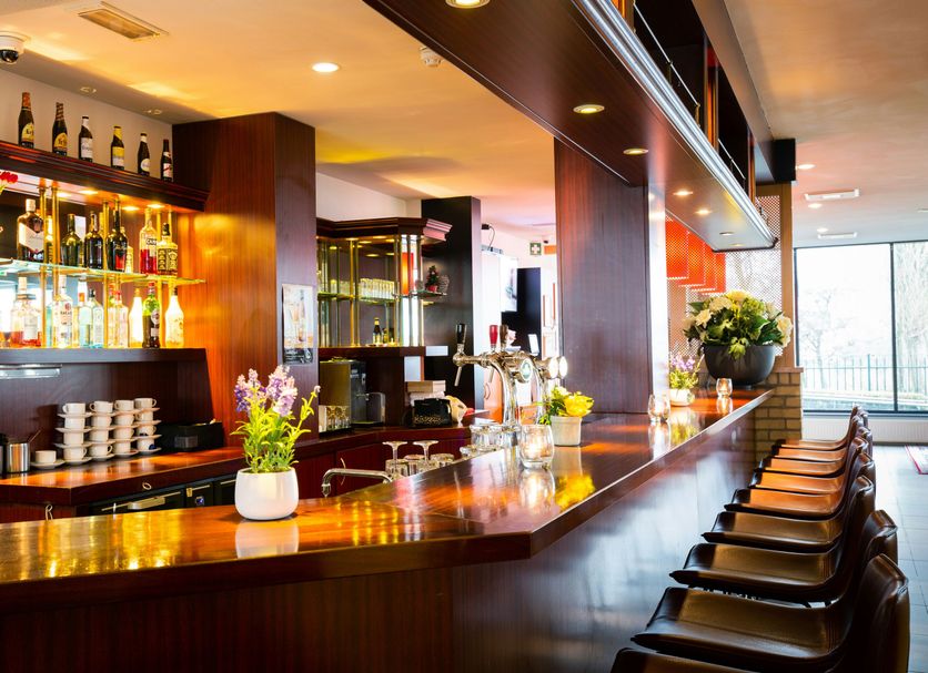 Bastion Hotel Dordrecht Papendrecht bar with long wooden counter and bar stools in Dordrecht