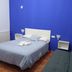 The Dreamers&Co Córdoba guest room with bed, blue accent wall and lounge chair