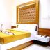 TR Residency in Pondicherry room with mustard bed, tufted headboard and white nightstand