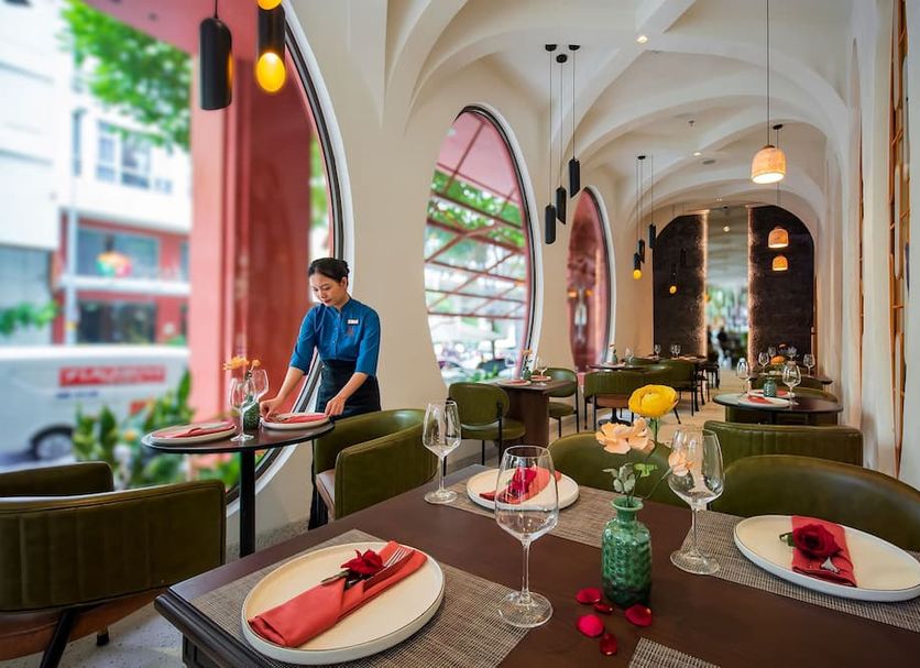 Me Saigon Boutique Hotel restaurant with arched windows and elegant table settings in Ho Chi Minh City