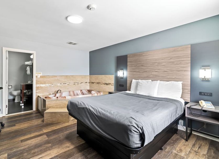 Plaza Inn Peabody guest room with king bed, seating area and wood-look flooring