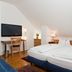 Hotel Garni Schacherer in Müllheim: twin beds, desk with chair, and TV in a compact guest room