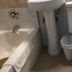 Diamond View Motel Susanville bathroom with tub, pedestal sink, toilet, and trash bin