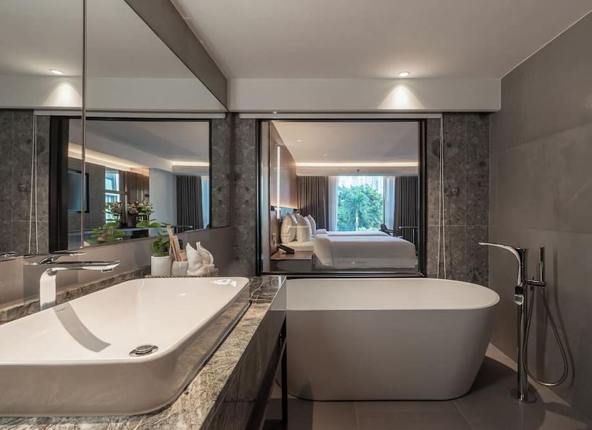 Gardina Asoke Hotel & Residence in Bangkok bathroom with freestanding tub, large mirror and walk-in shower