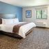 My Place Hotel-Idaho Falls, Id guest room with king bed, blue accent wall, window and TV