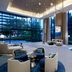 Somerset Rama 9 Bangkok lobby with floor-to-ceiling windows and seating overlooking trees in Bangkok