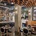 The Gordon Hotel Eugene interior with stylish dining area, bar seating, and exposed wooden ceiling beams
