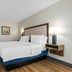 Hampton Inn Birmingham/Trussville guest room with two beds, wood floors, desk, and wall lamp in Trussville