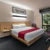 City Express by Marriott Oaxaca guest room with queen bed, desk, TV, and window view of trees