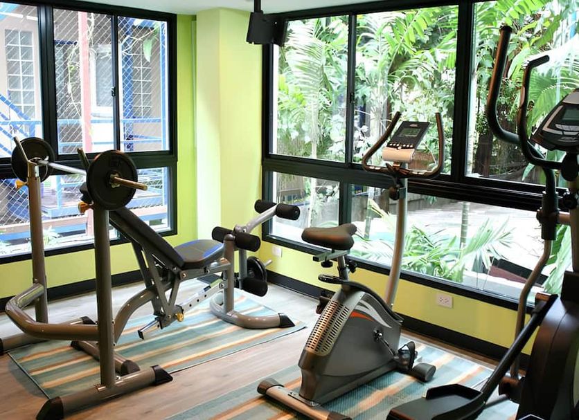 Silom Forest Exclusive Residence Bangkok gym with exercise bikes, weights and large tropical garden windows