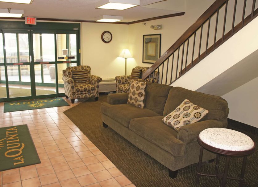 La Quinta Inn by Wyndham Omaha Southwest lobby seating area with couch, chairs and staircase in Omaha