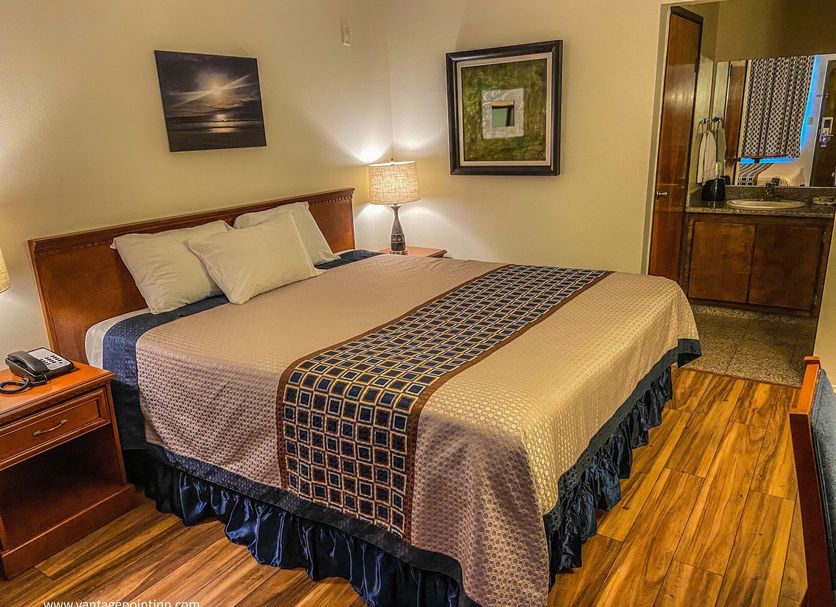 Vantage Point Inn - Woodland Hills guest room with king bed, nightstand lamp, and wood flooring