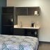 Studio 6 Huntsville kitchenette with mini fridge, microwave, sink and bed in a guest room