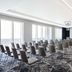 Hyatt Regency London Stratford conference room with rows of chairs and large windows overlooking water