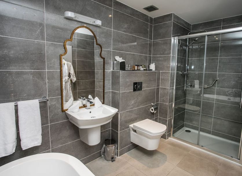 Longcourt House Hotel in Newcastle West bathroom with walk-in glass shower, wall-mounted sink and toilet