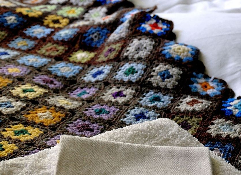 Nästegården Bed & Breakfast in Sätuna with folded embroidered linens on a bed
