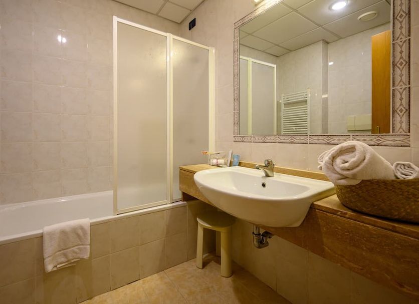 Hotel Torre di Pratolungo bathroom in Rome with bathtub, sink, mirror and shower screen