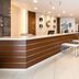 Comfort Hotel Tomakomai lobby with wood reception desk, seating area and bright modern lighting