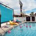 Hotel Zazz in Albuquerque rooftop pool with colorful lounge chairs and pink flamingos in the water