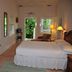 Casa 325 Key West guest room with bed, windows, and a view to the green outdoor area