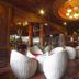 Majestic Oriental Hotel Siem Reap lobby lounge with woven white chairs and ornate carved wood ceiling
