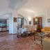 Le Rocche di Valiano in Vagliagli living room with beige sofas, dining table and cabinet