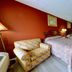 Dahlonega Mountain Inn guest room with two beds, armchair, TV and vanity in Dahlonega