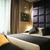 Triviho Hotel in Rome guest room with a large upholstered headboard, bed, and bedside lamps