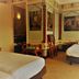 Hotel Courage Nijmegen room with twin beds, classical wall art, and a doorway to the bathroom