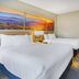 Days Inn Roanoke Near I-81 room with two beds, cityscape wall art and yellow chair in Roanoke