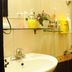 A25 Hotel Mai Hac De bathroom in Hanoi with sink, shower, wall shelf, and toiletries