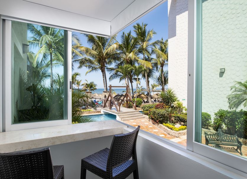 Hotel Villa Varadero in Nuevo Vallarta balcony with ocean view, palm trees, and pool walkway