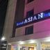 Hotel Asian Inn Nagpur exterior at night with illuminated sign and pink-lit facade