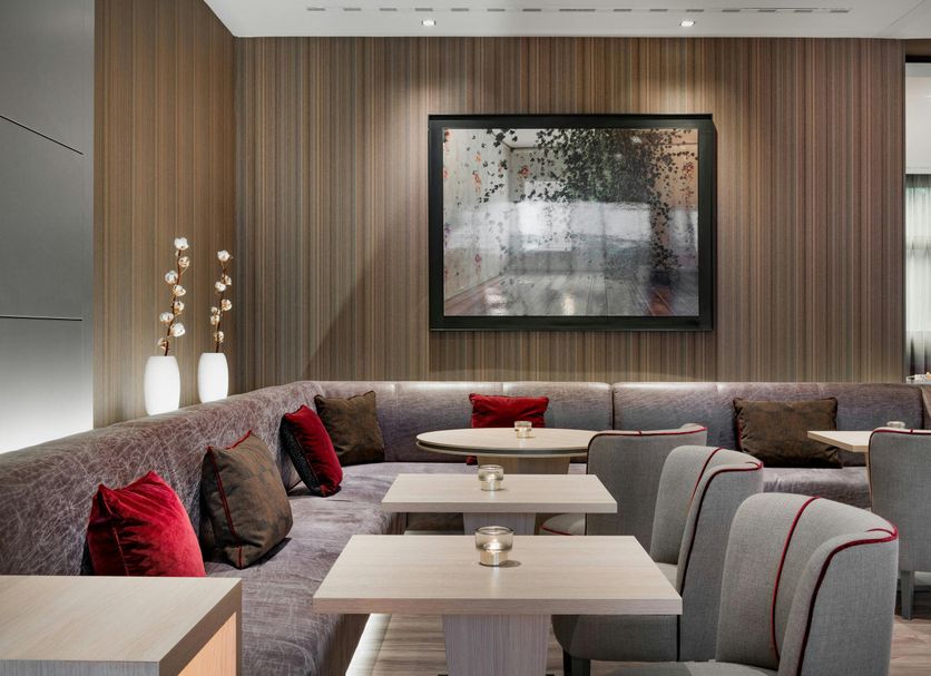 AC Hotels by Marriott Bologna lounge with curved seating and tables in a modern interior