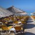 Hotel Loukas Vrachos beach loungers and thatched umbrellas on sandy shore in Vrachos, sea view