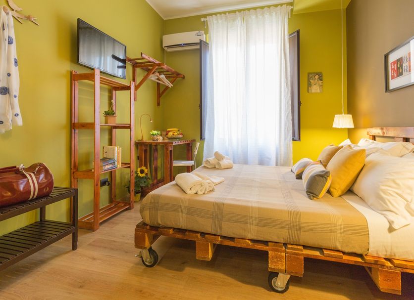 Miro Bed and Breakfast in Catania guest room with wooden bed, TV, luggage bench, and window