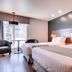 Hotel Marineau Shawinigan guest room with two beds, window seating, and modern lighting in Shawinigan