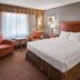 Days Inn by Wyndham Culpeper guest room with king bed, seating area, and window with sheer curtains