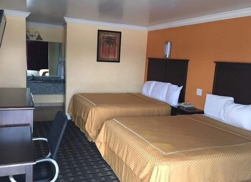 Express Inn West Memphis guest room with two double beds, TV, desk, and bathroom area