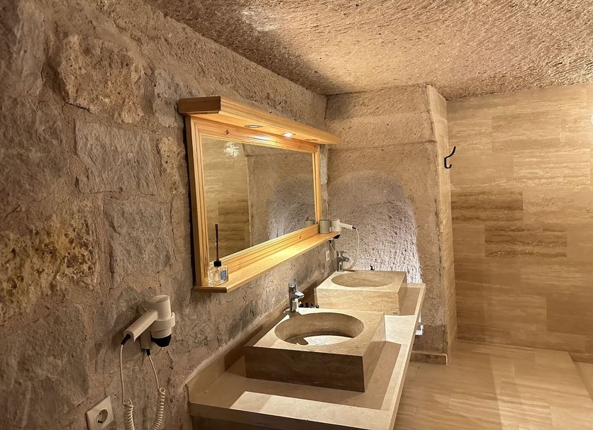 Kistar Cave Hotel, Uchisar cave bathroom with double sinks and stone walls