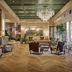 The Leo Kent Hotel, Tucson lobby with crystal chandelier, tufted chairs and tall windows