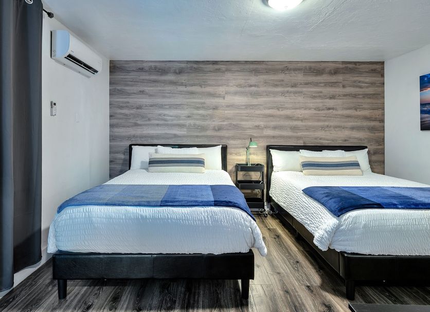 Oasis Hotel Fort Lauderdale guest room with two double beds and wood accent wall