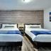 Oasis Hotel Fort Lauderdale guest room with two double beds and wood accent wall