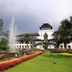 Hotel Tibera Taman Cibeunying in Bandung with landscaped garden, fountain, and white building