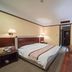 Hubin Bubugao Hotel in Qingyuan guest room with king bed, bedside lamps, TV and desk